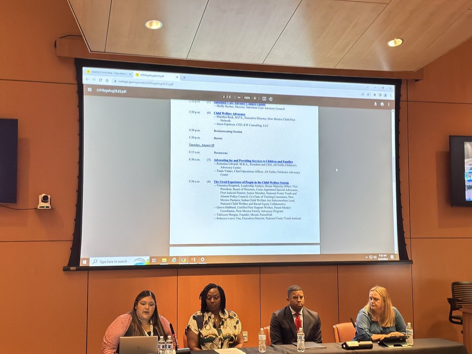 Panel dais with the New Mexico Legislative Health and Human Services Committee agenda projected behind, listing Takkeem Morgan among the invited speakers on the lived experience of people in the child welfare system